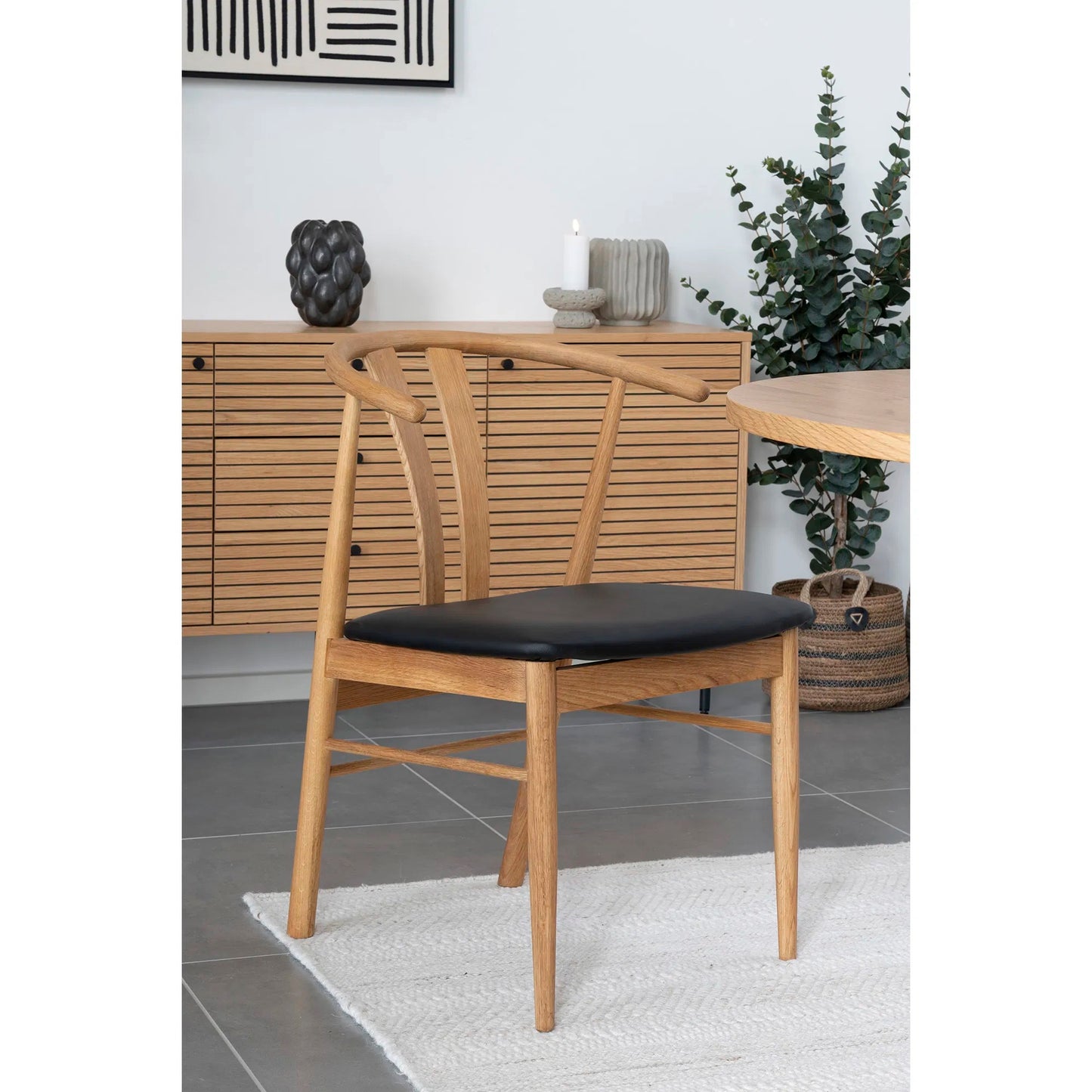 Svart keramikvas med runda formationer placerad i heminredning